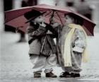 Τα παιδιά το περπάτημα στη βροχή με την ομπρέλα της